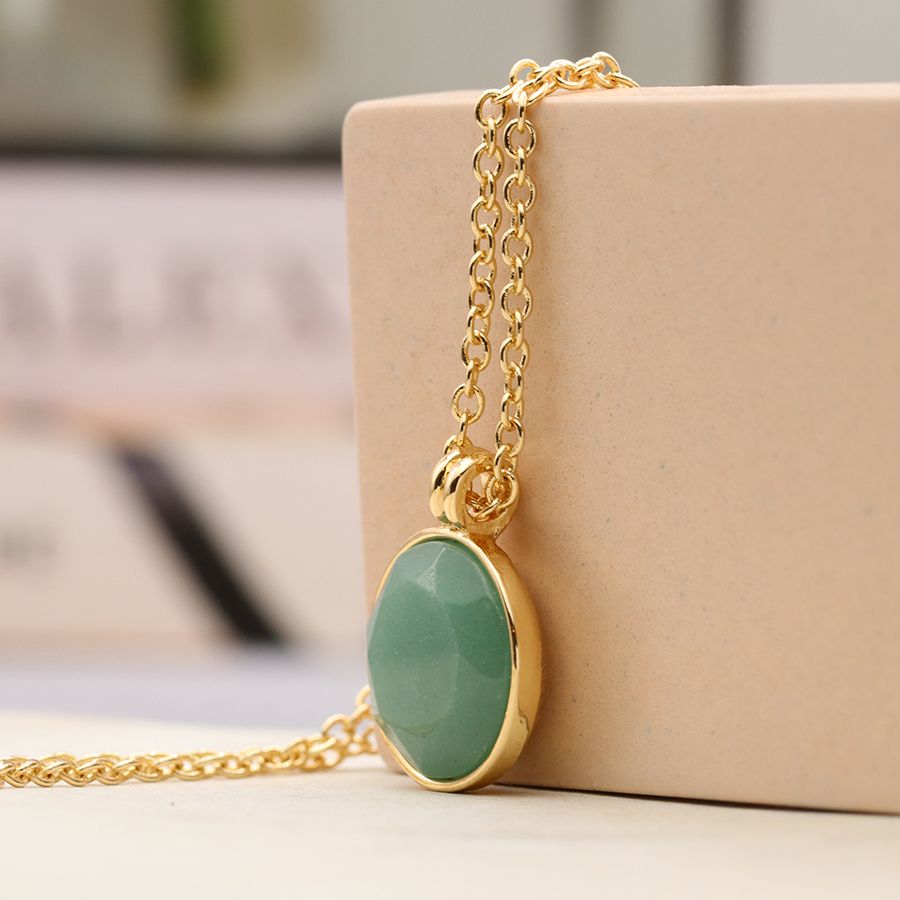 Premium Photo | A necklace with a green stone and a gold chain.